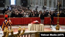 People wait in line to pay their respect to Pope Emeritus Benedict XVI laying in state at St. Peter's Basilica in the Vatican.