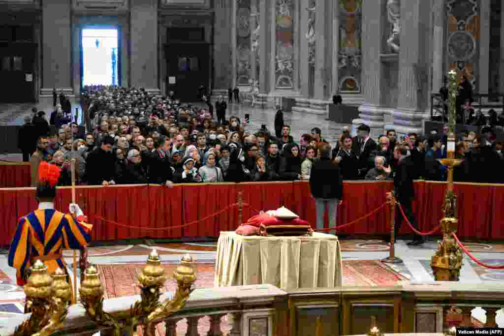 Луѓето чекаат во ред да му оддадат почит на почесниот папа Бенедикт Шеснаесетти во базиликата Св. Петар во Ватикан.