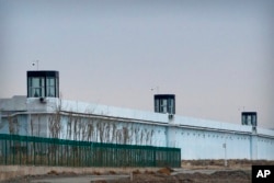 FILE - A person stands in a tower on the perimeter of the Number 3 Detention Center in Dabancheng in western China's Xinjiang Uyghur Autonomous Region, on April 23, 2021.