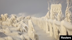 Ice formed by the spray of Lake Erie waves covers a walkway during a winter storm in Irving, New York, U.S., December 24, 2022