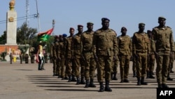 Des soldats de différents corps d'armée devant être décorés de médailles arrivent lors du 62e anniversaire de la création des Forces armées du Burkina Faso sur la place de la Nation à Ouagadougou le 1er novembre 2022.