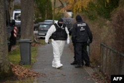 Police officers are seen in a street during a raid against alleged members of a far-right group suspected of plans to overthrow the government, in Berlin, Germany, Dec. 7, 2022.