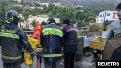 Rescuers help an injured person following a landslide on the Italian holiday island of Ischia, Italy, in this handout photo obtained by Reuters on November 26, 2022. 