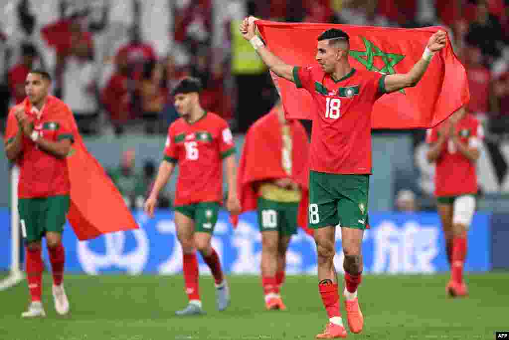 Jogador Jawad El Yamiq celebra com a bandeira de Marrocos.&nbsp;