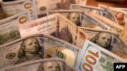 FILE — This picture taken on August 25, 2022 shows Egyptian pound and US dollar banknotes.