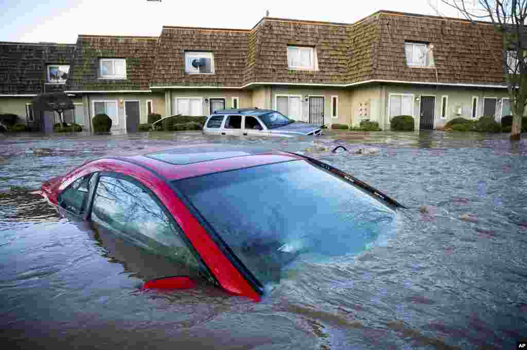 Floodwaters course through a neighborhood in Merced, California, Jan. 10, 2023. Following days of rain, Bear Creek overflowed its banks leaving dozens of homes and vehicles surrounded by floodwaters.