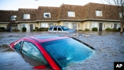 Floodwaters course through a neighborhood in Merced, California, on Jan. 10, 2023. Following days of rain, Bear Creek overflowed its banks leaving dozens of homes and vehicles surrounded by floodwaters. 