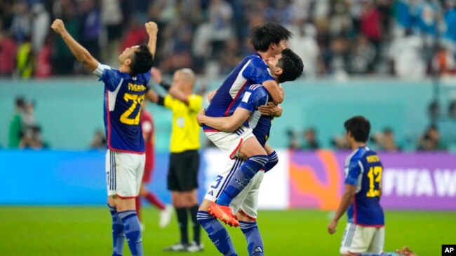 Japan players celebrate at the end of the World Cup group E soccer match between Japan and Spain, at the Khalifa International Stadium in Doha, Qatar, Dec. 1, 2022. Japan won 2-1.