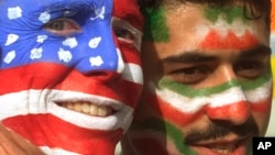 FILE - Mike Moscrop, left, from Orange County, Calif., poses with Amir Sieidoust, an Iranian supporter living in Holland outside the Gerlain Stadium in Lyon, June 21, 1998, before the start of the USA vs Iran World Cup soccer match. 