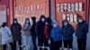 北京市民在宣傳習近平思想的標語牆前排隊等候接受核酸檢測。（2022年12月5日）