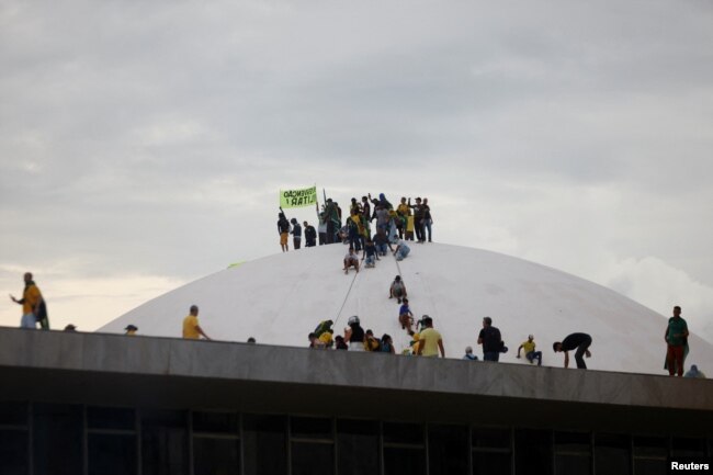 Los partidarios del expresidente de Brasil, Jair Bolsonaro, en la parte superior de la cúpula del Congreso Nacional durante una manifestación contra el presidente Luiz Inácio Lula da Silva, en Brasilia, Brasil, el 8 de enero de 2023.