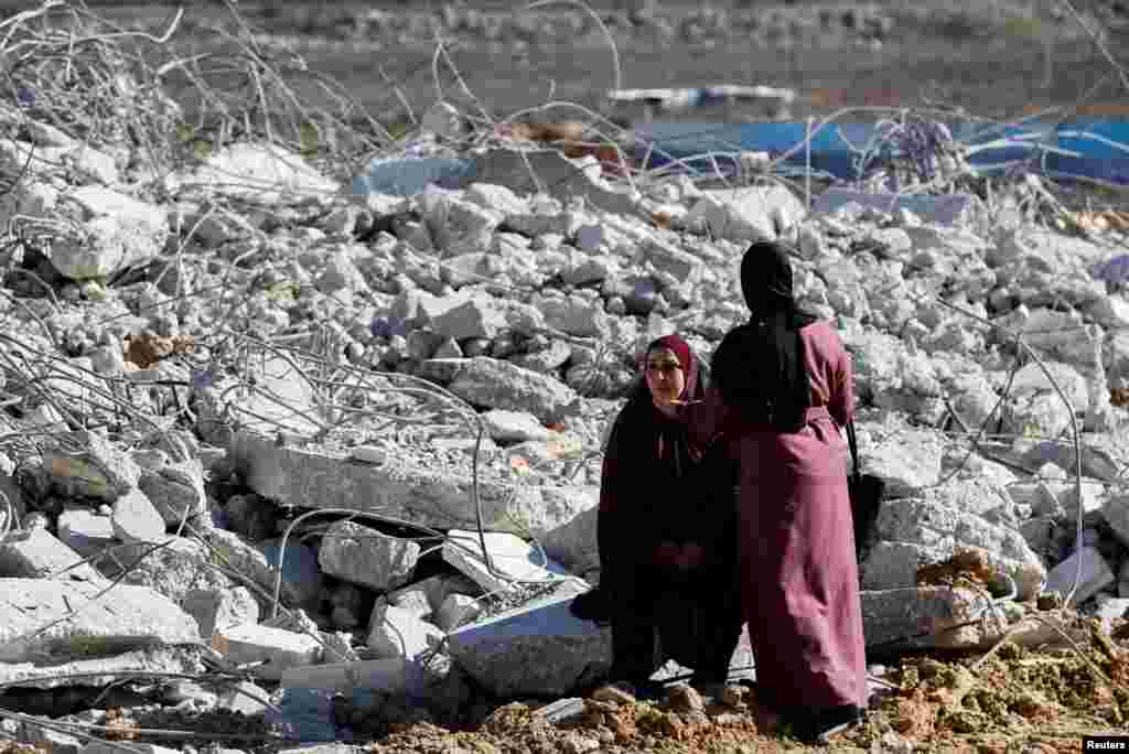 Една жена гледа како Израелците користат тешка машинерија за да урнат палестинска куќа во Хеброн, на окупираниот Западен Брег.