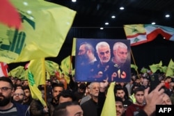Supporters of the Lebanese Shiite movement Hezbollah mark the third anniversary of death of top Iranian Revolutionary Guards commander Qasem Soleimani and Iraqi commander Abu Mahdi al-Muhandis, in Beirut's southern suburbs, Jan. 3, 2023.