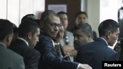 El vicepresidente ecuatoriano, Jorge Glas (centro), reacciona cuando llega a la corte para asistir a su juicio por soborno a la constructora brasileña Odebrecht, en Quito, Ecuador, el 13 de diciembre de 2017. 