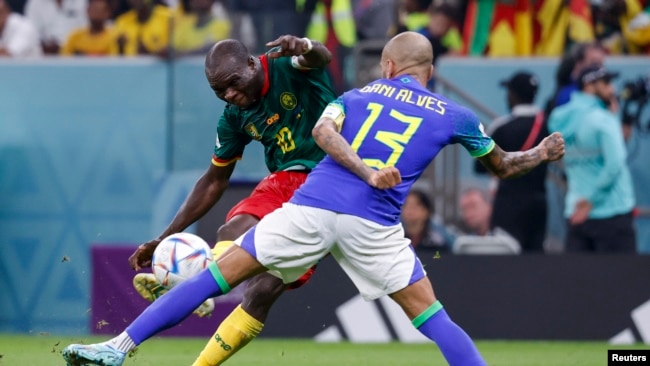 El delantero de Camerún Vincent Aboubakar (10) dispara contra el defensa de Brasil Dani Alves (13) en la segunda mitad durante un partido de la fase de grupos durante la Copa del Mundo de 2022 en el Estadio Lusail. Foto proporcionada por USA TODAY Sports a través de Reuters.