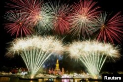 Fireworks explode over the Chao Phraya River during the New Year celebrations, in Bangkok, Thailand, Jan. 1, 2023.