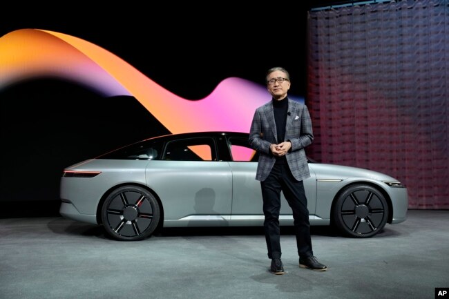 Kenichiro Yoshida, chairman, president and CEO of the Sony Group Corporation, stands in front of a newly unveiled electric vehicle prototype car Afeela, a joint venture between Sony and Honda, during a Sony news conference before the start of the CES tech show Wednesday, Jan. 4, 2023, in Las Vegas. (AP Photo/John Locher)