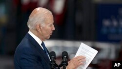 FILE - President Joe Biden looks at a document as he speaks at the Volvo Group Powertrain Operations facility in Hagerstown, Maryland, Oct. 7, 2022.