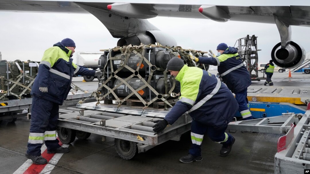 FILE - Workers unload a shipment of military aid delivered as part of the United States of America's security assistance to Ukraine, at the Boryspil airport, outside Kyiv, Ukraine, Feb. 11, 2022.
