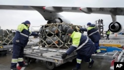 Trabajadores descargan un envío de ayuda militar entregado como parte de la asistencia de seguridad de EEUU a Ucrania, en el aeropuerto de Boryspil, en las afueras de Kiev, el 11 de febrero de 2022.