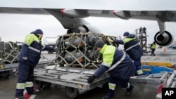 Sejumlah petugas di Bandara Boryspil, yang terletak di luar Kota Kyiv, Ukraina, mengeluarkan bantuan keamanan yang dikirim oleh AS untuk Ukraina pada 11 Februari 2022. (Foto: AP/Efrem Lukatsky)