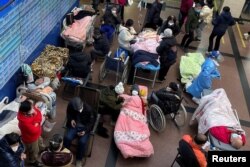 Pasien berbaring di tempat tidur dan tandu di lorong unit gawat darurat rumah sakit, di tengah wabah COVID-19 di Shanghai, China, 4 Januari 2023. (Foto: Reuters)