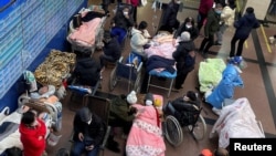တရုတ်နိုင်ငံ၊ ရှန်ဟိုင်းမြို့မှာ ကိုဗစ်ရောဂါလူနာတွေအဆမတန်များနေပြီး ဆေးရုံတွေမှာနေရာမဆန့်တော့လို့ လျှောက်လမ်းပေါ်မှာ တွန်းလှည်းတွေ၊ ဘီးတပ်ကုလားထိုင်တွေနဲ့ ကုသမှုခံယူနေကြရသူများ။ (ဇန်နဝါရီ ၄၊ ၂၀၂၃) 