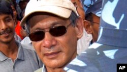 FILE - Police escort convicted French serial killer Charles Sobhraj from court in Katmandu, Nepal, on Aug. 12, 2004. 