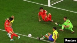 Jwe Sid Koreyen Son Heung-min choute balon an nan direksyon gol la pandan ko-ekipye li Cho Gue-sung ak Brezilyen Marquinhos ak Alisson reyaji, 5 Desanm, 2022. 