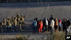 Militer AS menghentikan migran menyeberang ke El Paso, Texas, dilihat dari Ciudad Juarez, Meksiko, Selasa, 20 Desember 2022. (AP/Christian Chavez)