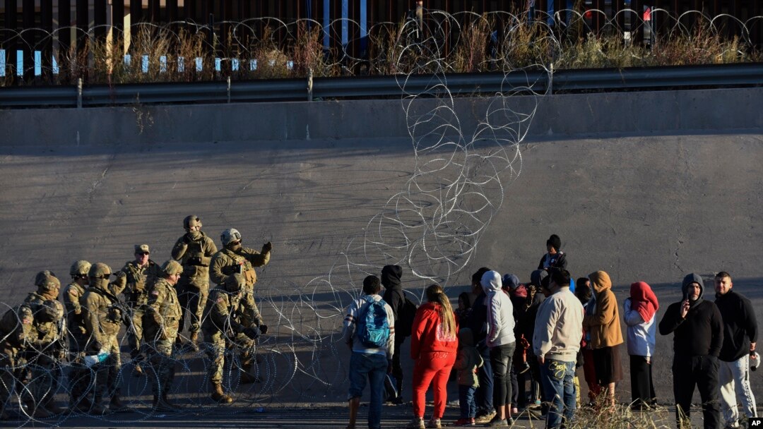 Anggota pasukan militer AS memberhentikan migran untuk tidak menyeberang ke wilayah El Paso, Texas, dari Ciudad Juarez, Meksiko, pada 20 Desember 2022. (Foto: AP/Christian Chavez)