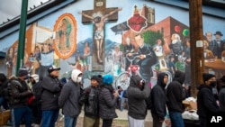 Sejumlah migran tampak mengantre makanan yang didonasikan oleh warga sekitar di El Paso, Texas, pada 18 Desember 2022. (Foto: AP/Andres Leighton)