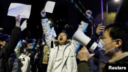 2022年11月28日，在新冠病毒疫情持續擴散之際，北京民眾為烏魯木齊火災遇難者守夜後，舉著白紙抗議中共當局的封控限制。