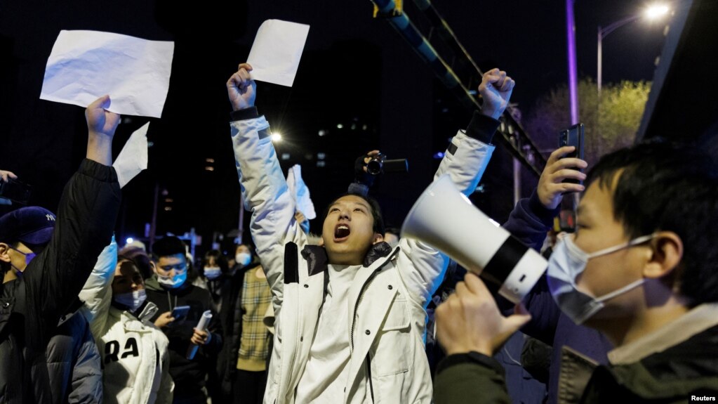 2022年11月28日，在新冠病毒疫情持续扩散之际，北京民众为乌鲁木齐火灾遇难者守夜后，举着白纸抗议中共当局的封控限制。(photo:VOA)