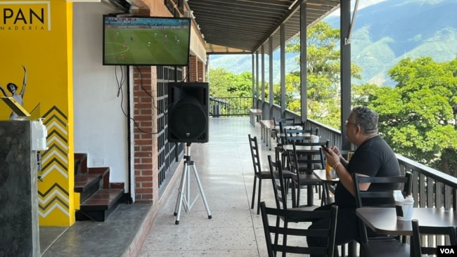 Un hombre mira un partido de la Copa Mundial de Fútbol en una panadería en Caracas, Venezuela, el lunes, 21 de noviembre de 2022.