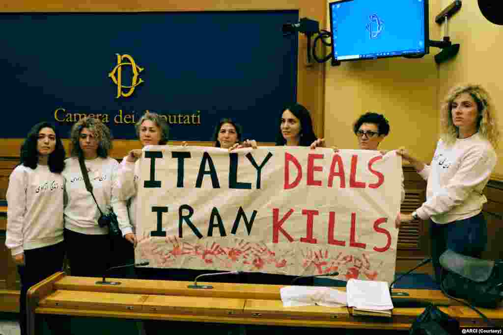 کنشگران ایرانی&zwnj;ایتالیایی در کنفرانس مطبوعاتی در مجلس سفلای ایتالیا بنری با مضمون &laquo;ایتالیا معامله می&zwnj;کند، ایران می&zwnj;کشد&raquo; در دست دارند
