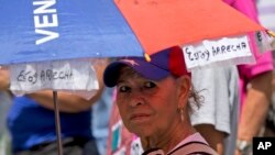 Una manifestante en el centro de Caracas porta una sombrilla con un mensaje expresando a su sentimiento de frustación por la crisis venezolana. Foto archivo, 12 de marzo, de 2018 