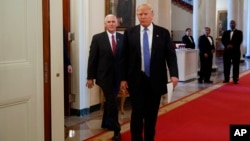 President Donald Trump, followed by Vice President Mike Pence, arrives for a meeting with manufacturing executives at the White House in Washington, Feb. 23, 2017.