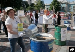 FILE - Protesters, critical of the government's handling of the economy, are seen banging on empty barrels as they rally in downtown in Kyiv, Ukraine, May 21. 2015.