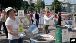 FILE - Protesters, critical of the government's handling of the economy, are seen banging on empty barrels as they rally in downtown in Kyiv, Ukraine, May 21. 2015.