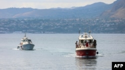 Sebuah kapal Penjaga Pantai dan sebuah kapal pemadam kebakaran Italia mencari enam orang lainnya yang hilang setelah menemukan korban akibat perahu layar yang tenggelam di lepas pantai Porticello, barat laut Pulau Sisilia, 19 Agustus 2024. (Igor Petyx / ANSA / AFP)