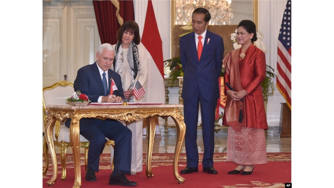 U.S. Vice President Mike Pence (left) with his wife, Karen, (second from left) signs the guest book as Indonesian President Joko Widodo and his wife, Iriana, look on, during their meeting at Merdeka Palace in Jakarta, Indonesia, April 20, 2017.