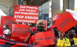 Members of South Africa’s biggest trade union group, COSATU, carry placards during a nationwide protest against job losses, wage curbs and corruption cases, in Johannesburg, Oct. 7, 2021.