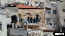 Israeli guards stand on the balcony of a house purchased by Jews in the mostly Arab neighborhood of Silwan in east Jerusalem, Oct. 20, 2014.
