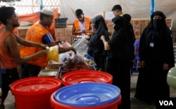 Rohingya refugees line up to receive food at a World Food Programme distribustion center April 2, 2019. (Hai Do/VOA)