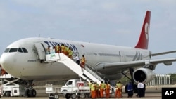 Employees work on a Turkish Airlines plane after its arrival at Aden Abdulle International Airport in Somalia's capital Mogadishu, March 6, 2012