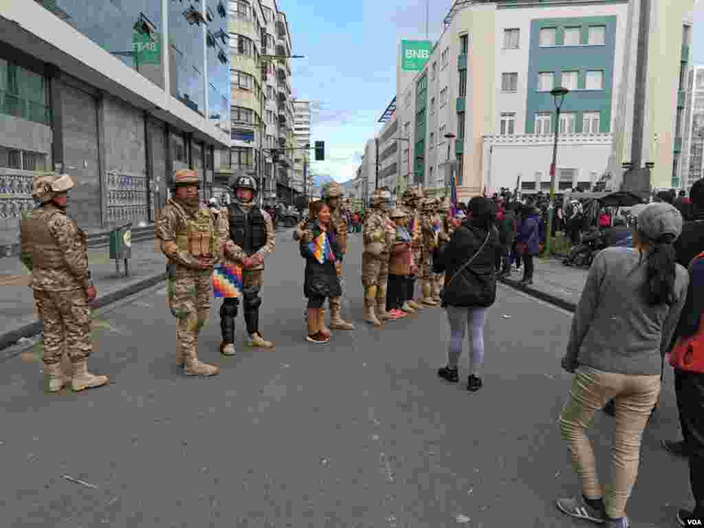 Personas que critican la unión entre militares y policías se sacan fotografías con los militares. 