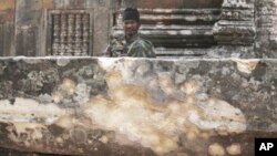 A Cambodian army soldier sits at damaged Cambodia's 11th century Hindu Preah Vihear temple.