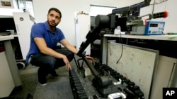 ARSIP - Foto yang diambil tanggal 28 Agustus 2018, insinyur perangkat lunak, Nicholas Otero, dari Woburn, Massachusetts berbicara dengan koleganya tentang fitur robot Centaur, kanan, di Endeavor Robotics di Chelmsford, Massachusetts (foto: AP Photo/Steven Senne)