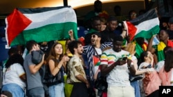 FILE - Spectators hold Palestinian flags as they watch the men's group D match between Israel and Mali at the Parc des Princes during the 2024 Summer Olympics, July 24, 2024, in Paris, France.